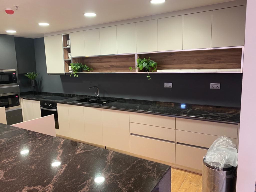 Sleek and modern kitchen interior featuring a large island and open shelving in a contemporary setting.