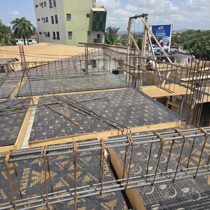 Piles of durable concrete hollow blocks and construction materials ready for masonry work at an Abelemkpe site.