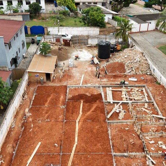 Progress update showing ground-floor blockwork walls rising at a multi-story building site in Abelemkpe